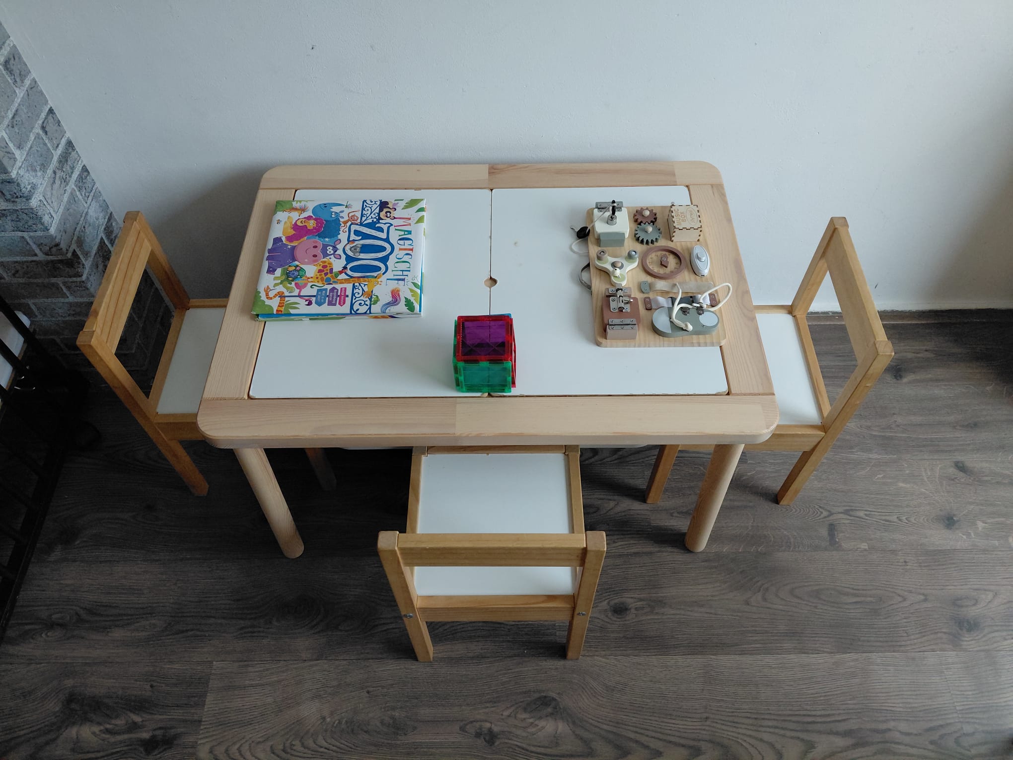 Kindertafel met stoelen, boek en houten activiteitenspeelgoed